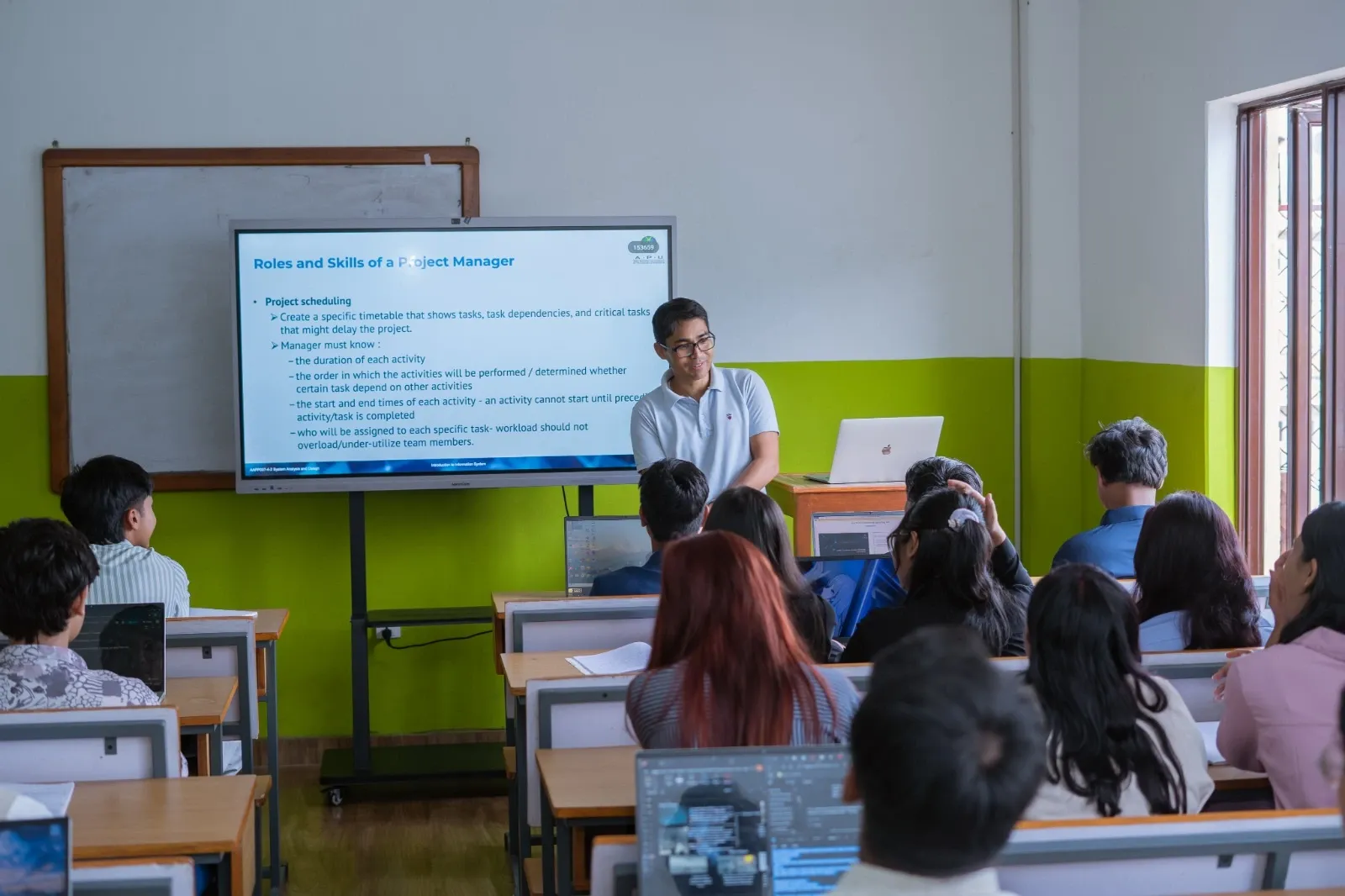 Classroom full of students with a screen