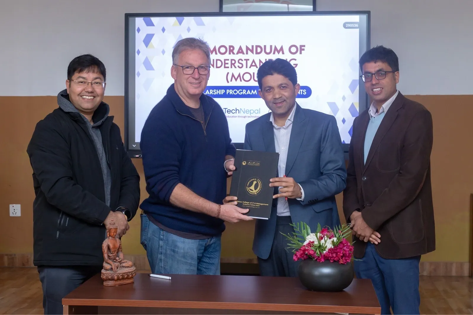 Few person holding out a certificate and posing for the camera